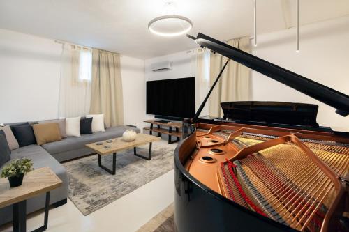 a living room with a piano and a couch at Villa Nausithoe 1 Paros in Logaras