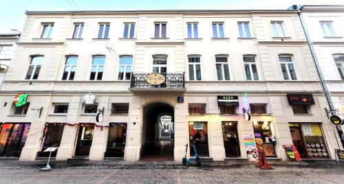 a large white building with a clock on it at Chmielna 5 Rooms & Apartments in Warsaw