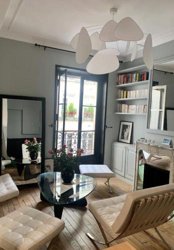 un salon avec une table en verre et des chaises dans l'établissement Heart of marais calm and charming NEW, à Paris