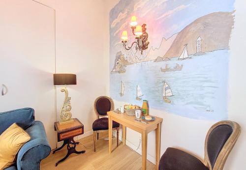 d'un salon avec une table et une peinture murale. dans l'établissement Nestor&Jeeves - PALAIS ALICE - Central - Very close sea, à Nice