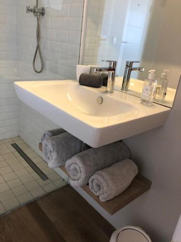a bathroom with a sink and towels under a mirror at Small Bay Beach Suites in Cape Town