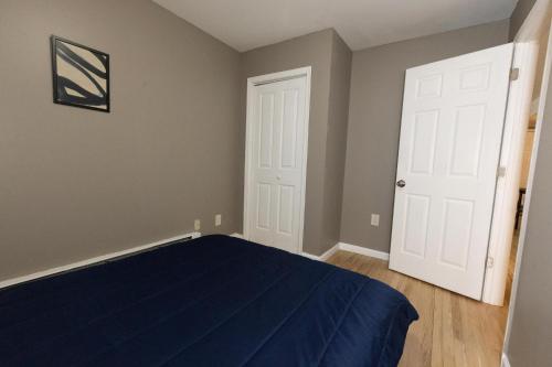 1 dormitorio con cama azul y puerta blanca en 2-Bed Stylish Space mins to NYC, en Jersey City