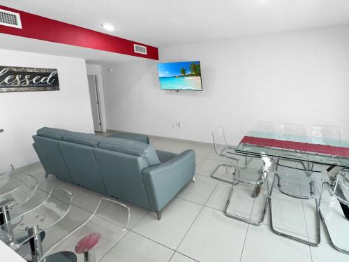 a waiting room with glass tables and a couch at Vacay Spot experience Luna Sky! 65" TV BAR, BBQ, SHOWER massage jets, music, go to FL Keys in Homestead