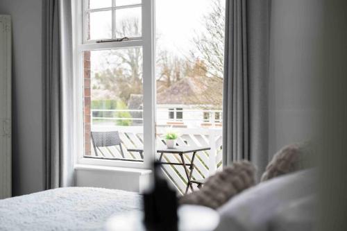 a bedroom with a window looking out at a patio at The Lymington Hub Slps 13 hot tub/chef/spa in Lymington