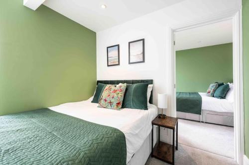 a bedroom with two beds and a mirror at The Lymington Hub Slps 13 hot tub/chef/spa in Lymington