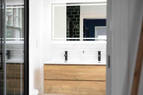a bathroom with a sink and a mirror at The Lymington Hub Slps 13 hot tub/chef/spa in Lymington
