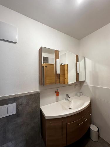 a bathroom with a sink and a mirror at Apartment Alpenstyle Ennstal in Aich