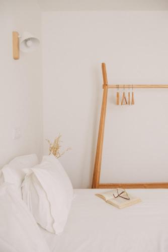 a white bed with a pair of glasses on it at Pure Flor de Esteva in Vila do Bispo