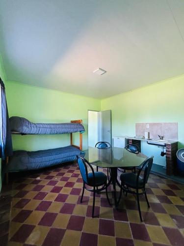 um quarto com uma mesa e cadeiras e uma cozinha em Casa de Campo em San Pedro