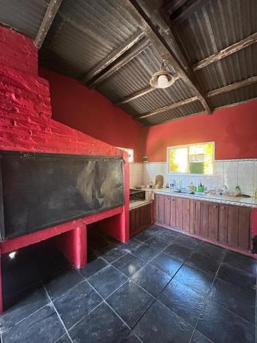 una gran pared roja en una cocina con un gran banco en Casa de Campo en San Pedro