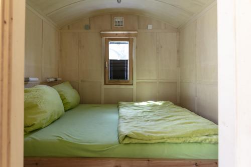 een bed in een kleine kamer met een raam bij Wagenburg-Solling in Neuhaus
