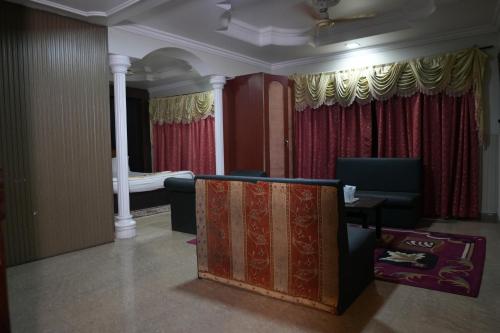 伯杰默里Hotel Indraprastha pachmarhi的客厅配有红色窗帘和沙发