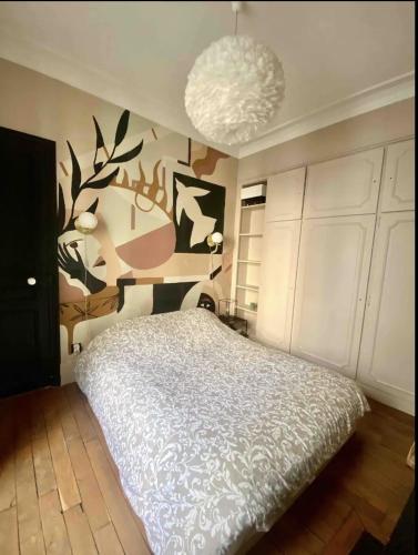 une chambre avec un grand lit et un lustre dans l'établissement Heart of marais calm and charming NEW, à Paris
