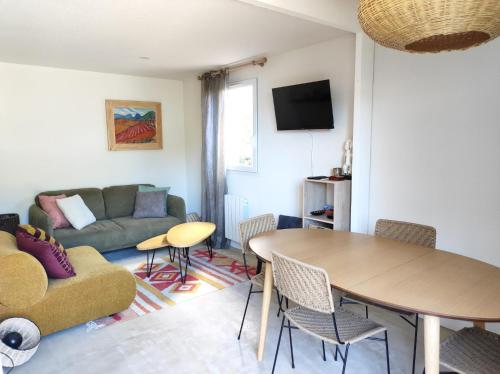 een woonkamer met een tafel en een bank bij Duplex dans résidence avec Piscine à Uzès in Uzès