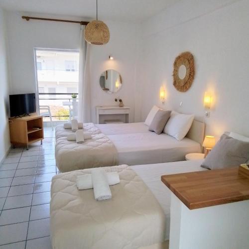 a hotel room with two beds and a television at Villa Thalassa Apartments in Pefkochori