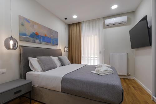 una camera con un grande letto e una TV a schermo piatto di Magnificent Riviera Residence ad Atene