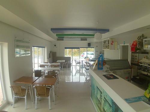 a dining room with tables and chairs and a counter at Hotel Baleal Spot in Baleal