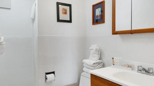 a white bathroom with a sink and a shower at Montauk Oceanside Suites in Montauk