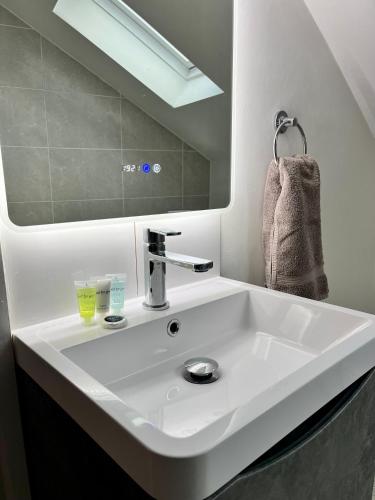 a white sink in a bathroom with a mirror at Apartments @52 in Bridlington