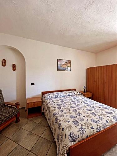 een slaapkamer met een bed en een stoel bij Case vacanze le Buganville in Ischia