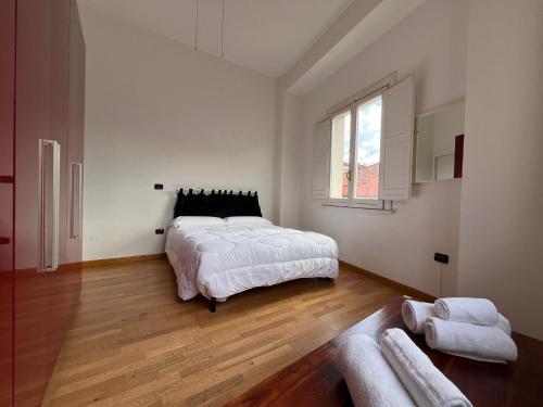 una camera bianca con un grande letto e una finestra di La Piazzetta ad Avellino