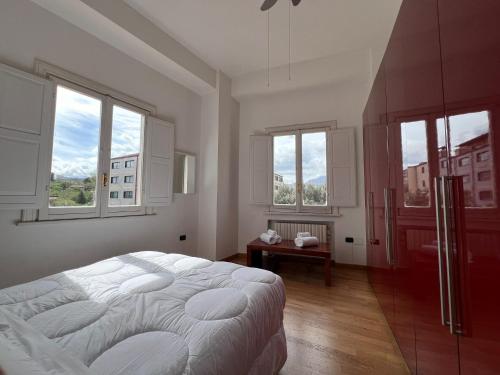 una camera bianca con un grande letto e finestre di La Piazzetta ad Avellino