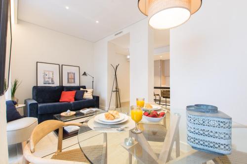 uma sala de estar com uma mesa e um sofá em Palafox Design - Darya Living em Madrid