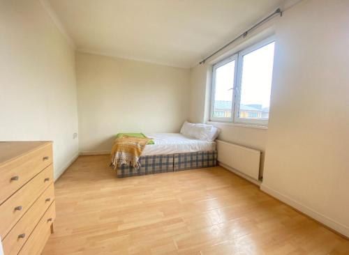 Habitación pequeña con cama y ventana en Modern Room for Rent in Vibrant E14: Your Urban Sanctuary Awaits! en Londres