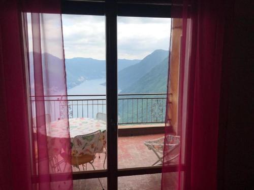 a view from a window of a balcony with a table at VillaMarinaPigra Lake View Apartments in Pigra