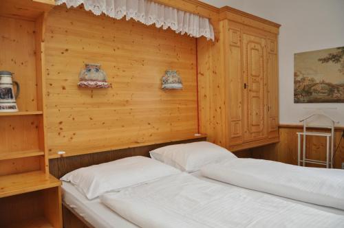 two beds in a room with wooden walls at Haus Weisses Lamm in Weitensfeld