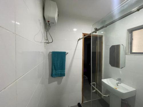 a white bathroom with a sink and a shower at American mall in Accra