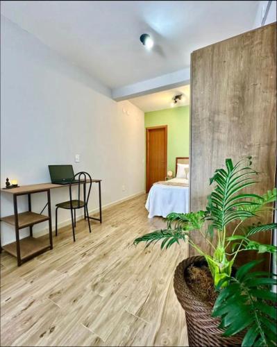 Zimmer mit einem Schreibtisch und einem Bett mit einem Laptop in der Unterkunft Apartamentos - Estúdios in São José