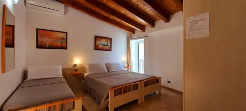 a bedroom with two beds and a window at B&B L'Antica Torre in Pozzallo