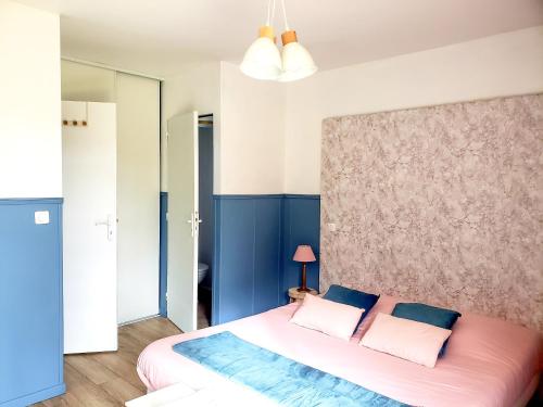 a bedroom with a large bed with blue walls at La petite forêt in Mons-Boubert