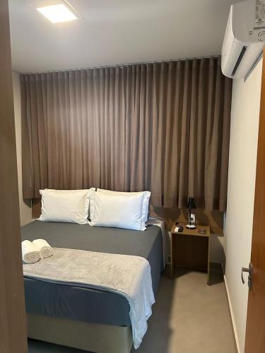 a hotel room with a bed and a table at Hotel Cabana in Caetanópolis