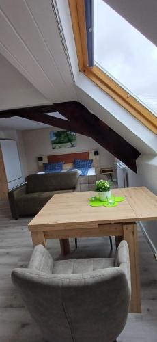 a wooden table and chairs in a living room at Pension am Lieserpfad in Manderscheid