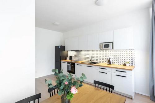 una cucina con armadi bianchi e tavolo in legno di Appartamento a Soria a Soria