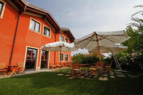 een patio met tafels en parasols voor een gebouw bij Albergo della Ceramica in Villanova Mondovì