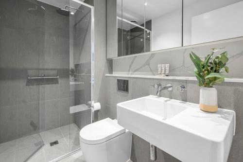 uma casa de banho branca com um lavatório e um WC em Chic Stature Southbank 1 Bed em Melbourne