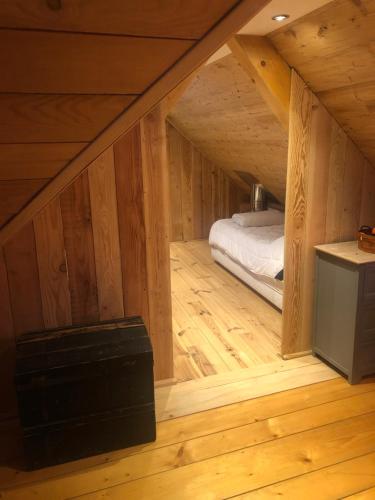 Großes Holzzimmer mit einem Bett im Dachgeschoss in der Unterkunft Au croque nature in Soultzeren