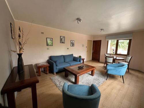 a living room with a blue couch and a table at Hotel Serena Suite in La Serena