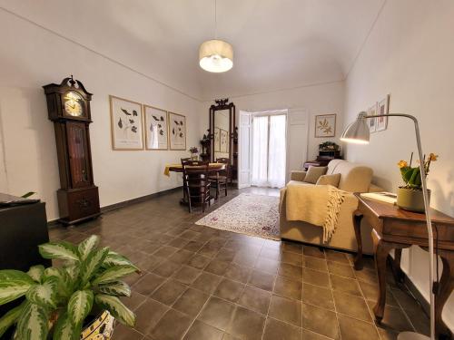 a living room with a couch and a grandfather clock at B&B Loft Famiglia Arezzo in Ragusa