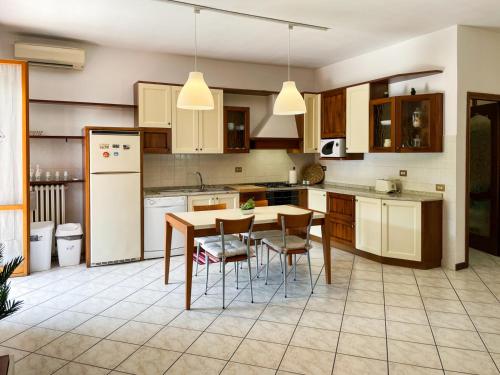 a kitchen with a table and chairs and a refrigerator at Torre Apartment - Affitti Brevi Italia in Modena