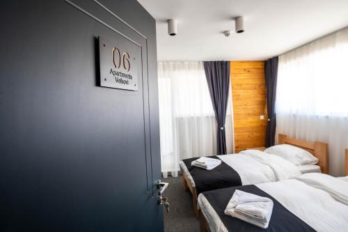 a room with two beds and a blue door at Velkov Apartments in Vinica