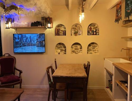 a dining room with a table and some pictures on the wall at Impasse des Mystères - La maison des Sorciers Léhon/Dinan in Dinan