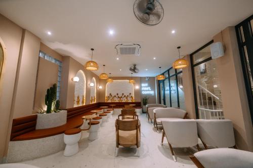 un salón con sillas blancas y una sala de espera en La Beaute Hotel - Quy Nhơn, en Quy Nhon