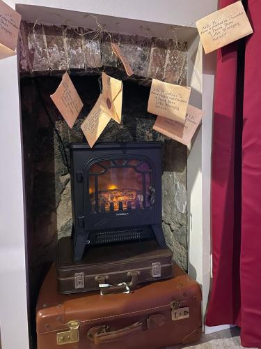 a fireplace with a stove on top of two suitcases at Impasse des Mystères - La maison des Sorciers Léhon/Dinan in Dinan
