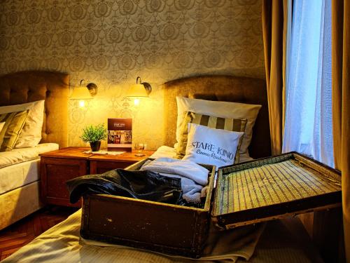 an old suitcase sitting on a bed in a bedroom at Stare Kino Cinema Residence in Łódź