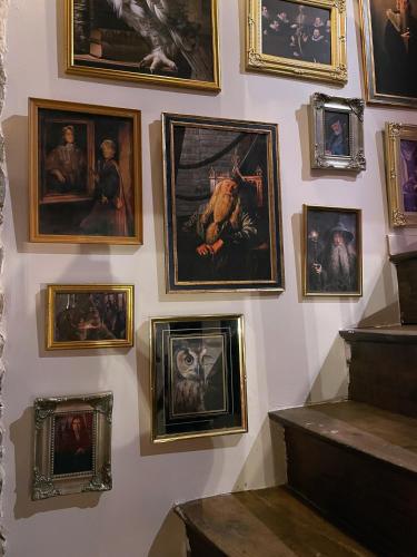 a wall with a bunch of paintings on a wall at Impasse des Mystères - La maison des Sorciers Léhon/Dinan in Dinan