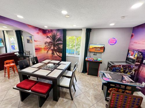 uma sala de jantar com uma mesa e um jogo de vídeo em Vacay Spot Happy Escape 15 Min Beach Massage Shower Prime LOC! 6 blocks away from Bars, Nite Clubs, Res, Shops em Miami